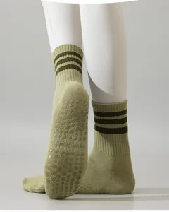 Chaussettes de yoga vertes avec semelles antidérapantes et poignets rayés pour femmes pilates.