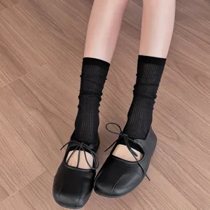 Black ribbed mid-tube socks and ballet shoes worn on legs, summer thin style fashion view.