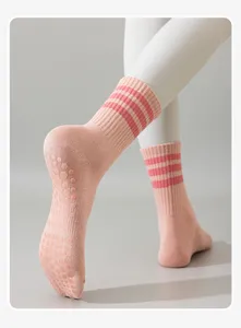 Gros plan de chaussettes de yoga antidérapantes, chaussettes de sport roses à revers rayés