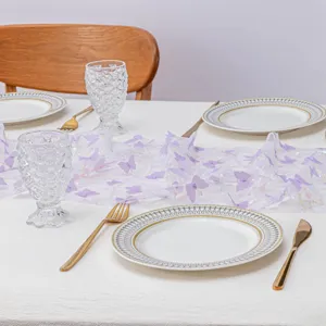 Vista dettagliata del runner da tavola in tulle viola con farfalle 3D e paillettes.