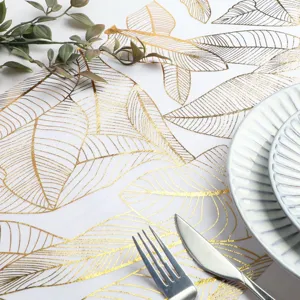 Détail de chemin de table à motif de feuilles dorées, élégant tissu de décoration.