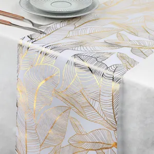 Chemin de table feuilles dorées détail, déco élégante blanche et or pour mariage et fête.