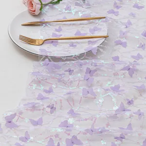 Dettaglio del runner da tavola in tulle con farfalle 3D viola e paillettes per feste.