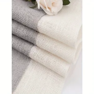 Vista dettagliata del runner da tavola in juta grigia e beige rustico con un delicato supporto.