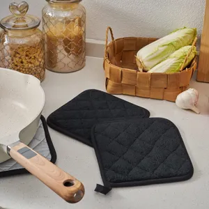 Durable kitchen pot holders and hot pads in black towel cloth, detail view for baking use.