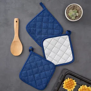 Set of blue and white quilted kitchen potholders with heat resistant fabric and hanging loops.