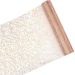 Dettaglio runner da tavola a rete geometrica dorata, rotolo di tessuto decorativo.