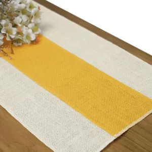 Primo piano di un runner da tavola in juta gialla e beige, decorazione rustica per matrimoni.