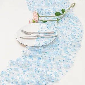Dettaglio del runner da tavola in tulle con farfalle 3D blu e paillettes per decorazioni nozze.