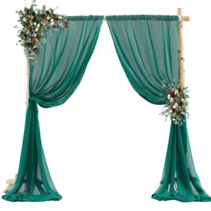 Vista dettagliata del drappo per arco nuziale in chiffon verde scuro con decorazione floreale.