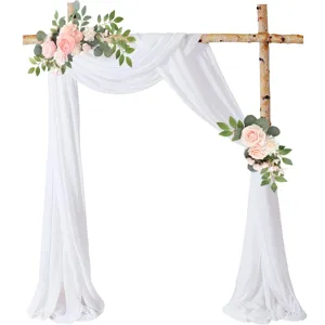 Vista dettagliata della decorazione dell'arco nuziale con drappo in chiffon bianco e fiori.
