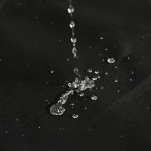 Primo piano dettagliato del tessuto impermeabile che mostra un eccellente effetto idrorepellente.