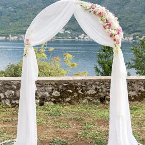 Vista dettagliata del drappo per arco nuziale in chiffon bianco con decorazione floreale.