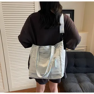 Vista posteriore di una donna con una grande borsa tote in tela azzurra per scuola