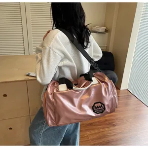 Large capacity pink waterproof duffel bag shown on model shoulder for gym and travel use