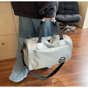 Silver large capacity waterproof duffel bag held by a person in lifestyle setting