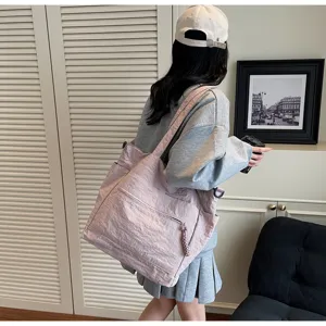 Vista dettagliata della grande borsa tote in tela rosa indossata da una modella casual