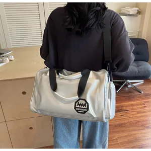 Large grey waterproof travel bag with shoulder strap shown in a professional lifestyle setting