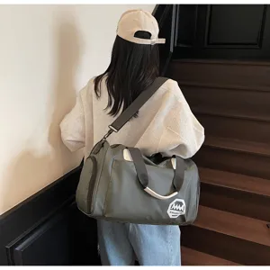 Back view of model carrying a large army green waterproof travel duffel bag on stairs.