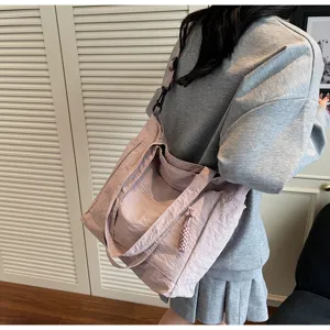 Grande borsa tote in nylon malva indossata da una modella in un ambiente domestico