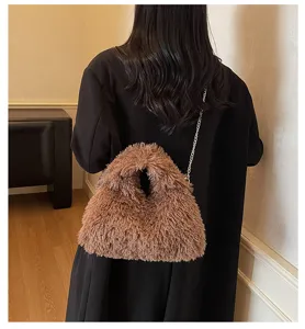 Modell trägt eine braune, flauschige Kettentasche aus weichem Lammfell-Imitat Stoff