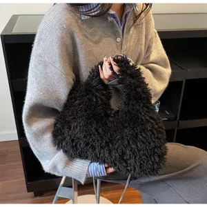 Nahaufnahme einer flauschigen schwarzen Kunstlammwoll-Beuteltasche mit Kettenriemen