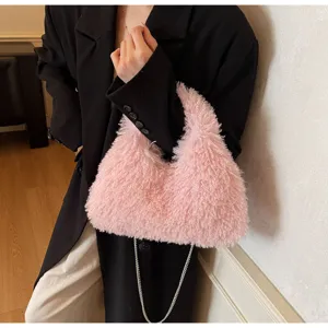 Modell hält eine rosa flauschige Kunstlammfell-Schultertasche mit silberner Gliederkette
