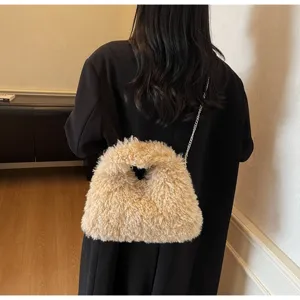 Rückansicht einer flauschigen beigen Lammwoll-Umhängetasche mit Silberkette auf Mantel.