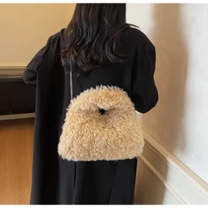 Detailansicht einer flauschigen Lammwolltasche mit silberner Kette auf einem schwarzen Blazer.