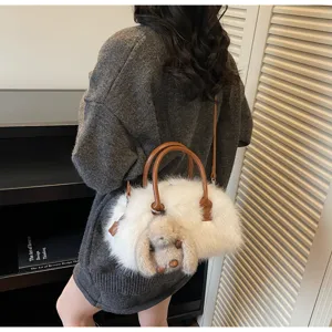 Elegant white faux fur Boston bag featuring a cute plush rabbit charm and brown straps