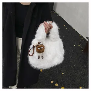 Close-up detail shot of white fluffy plush tote handbag with cute doll charm for winter style