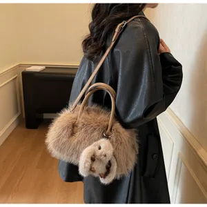Soft faux fur Boston bag with cute rabbit charm worn by a model in a winter outfit