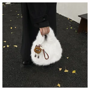 Detailed view of the stylish white fluffy plush handbag with a cute brown charm pendant.