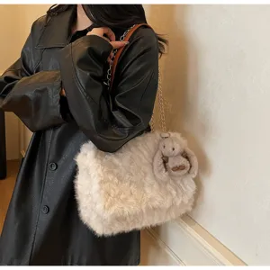 Detailansicht der cremefarbenen Plüschtasche mit Kettenriemen und Hasenanhänger.