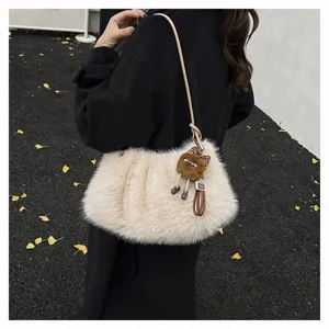 Nahaufnahme einer flauschigen cremefarbenen Kunstpelztasche mit schwarzem Mantel