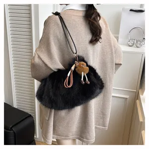Detailansicht der weichen schwarzen Kunstpelz-Schultertasche mit einem Plüsch-Anhänger