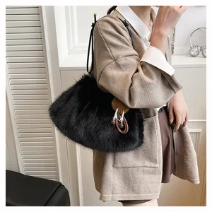 Detail einer schwarzen Plüsch-Achseltasche getragen mit einem modischen beigen Cardigan.