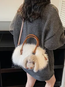 Elegant white plush faux fur Boston bag with cute bunny charm and adjustable brown strap.