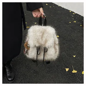 Stylischer weißer Kunstpelz-Rucksack mit Bärenanhänger, ideal für Herbst und den Winter