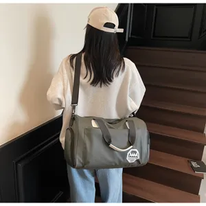 Back view of a person carrying a large olive green waterproof travel duffel bag on stairs