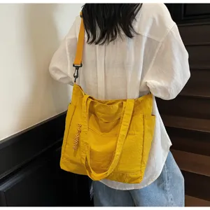 Vista posteriore di una donna con una grande borsa tote in tela gialla sulle scale