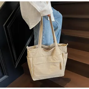 Vista dettagliata di una borsa tote in tela beige capiente portata su una scala