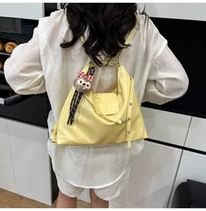 Stylish yellow patent leather multi-purpose tote backpack with cute plush pendant.