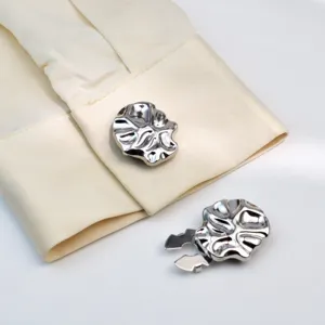 Detailed view of stylish silver metallic irregular shirt buttons and cufflinks for apparel.