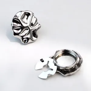 Detailed view of irregular silver metal buttons and backing components for stylish clothing DIY.