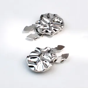 Detailed view of silver metallic irregular shaped shirt clips and decorative accessories.