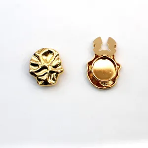Detail shot of golden metallic irregular shirt accessory, showing front and back view.