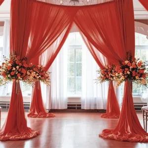 Vista dettagliata delle tende drappeggiate per arco nuziale in chiffon rosso per eventi.