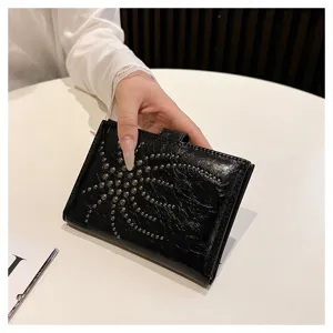 Nahaufnahme des schwarzen Leder-Reisepass-Etuis mit stylischem Metallnieten-Sternenmuster.
