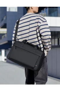 Vista dettagliata di una borsa da viaggio nera indossata da un modello, con tracolla e design.